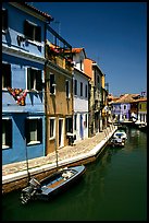 Canal surrounded by houses painted  a multitude of bright colors, Burano. Venice, Veneto, Italy