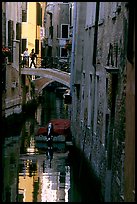 Pedestrians on a bridge over a narrow canal. Venice, Veneto, Italy