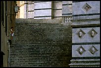 Woman cleaning up besides the Duomo stairs. Siena, Tuscany, Italy (color)