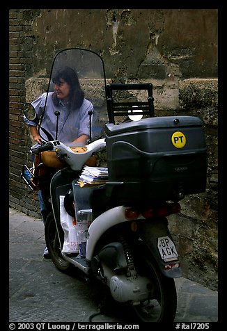 Delivering mail from a scooter. Siena, Tuscany, Italy