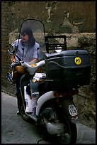 Delivering mail from a scooter. Siena, Tuscany, Italy (color)