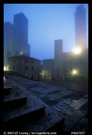 Piazza del Duomo at dawn in the fog. San Gimignano, Tuscany, Italy (color)