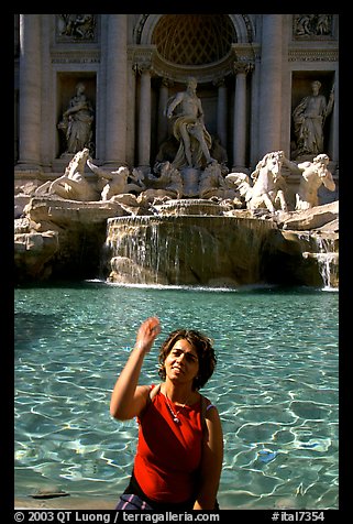 Tourist tosses a coin over her shoulder in the Trevi Fountain. Rome, Lazio, Italy (color)