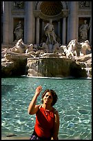 Tourist tosses a coin over her shoulder in the Trevi Fountain. Rome, Lazio, Italy (color)