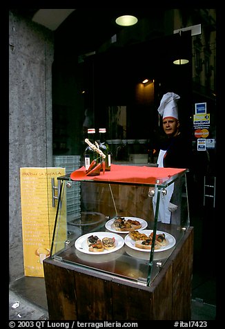 Chef at restaurant doorway with appetizers shown in glass case. Naples, Campania, Italy