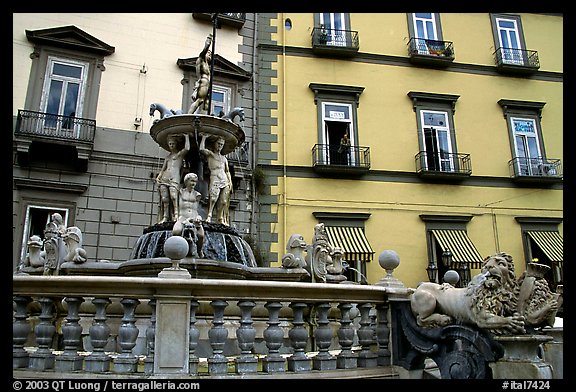 Fountain with man at balcony in background. Naples, Campania, Italy