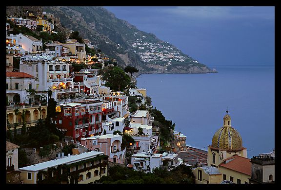 Chiesa di Santa Maria Assunta and houses on steep hills at dusk, Positano. Amalfi Coast, Campania, Italy