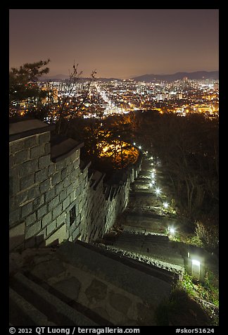Path, wall, and city lights, Suwon Hwaseong Fortress. South Korea (color)