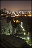 Path, wall, and city lights, Suwon Hwaseong Fortress. South Korea (color)