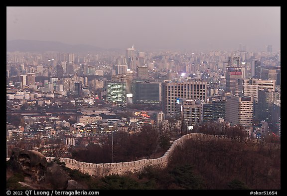 Old fortress wall and high-rises at dusk. Seoul, South Korea (color)