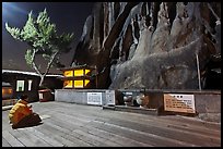 Woman wearing parka worshipping at Seon-bawi. Seoul, South Korea (color)