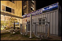 Public exercise equipment and buildings at night, Seogwipo. Jeju Island, South Korea ( color)