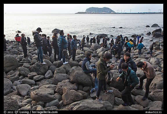 Tourists on rocky beach, Seogwipo. Jeju Island, South Korea (color)