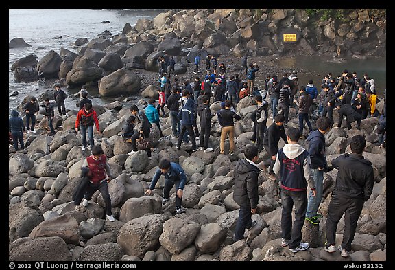 Crowd on rocky beach, Seogwipo. Jeju Island, South Korea (color)