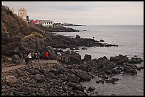 Tourists at Yongduam Rock, Jeju-si. Jeju Island, South Korea (color)