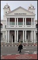 Man in suit crossing streets towards court building. George Town, Penang, Malaysia (color)