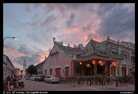 Temple and distant minaret at sunset. George Town, Penang, Malaysia