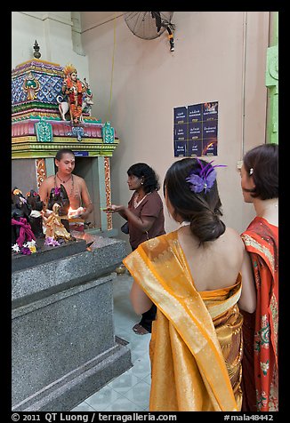 Holy man distributes fire to women, Sri Mariamman Temple. George Town, Penang, Malaysia (color)