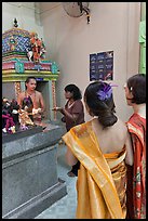 Holy man distributes fire to women, Sri Mariamman Temple. George Town, Penang, Malaysia (color)