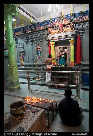 Holy man tends to altar, Hindu temple. George Town, Penang, Malaysia (color)