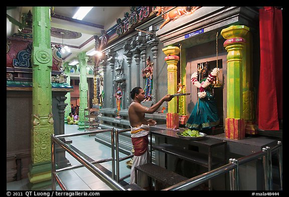 Holy man lights altar inside Sri Mariamman Temple. George Town, Penang, Malaysia (color)