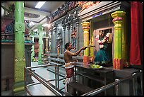 Holy man lights altar inside Sri Mariamman Temple. George Town, Penang, Malaysia (color)