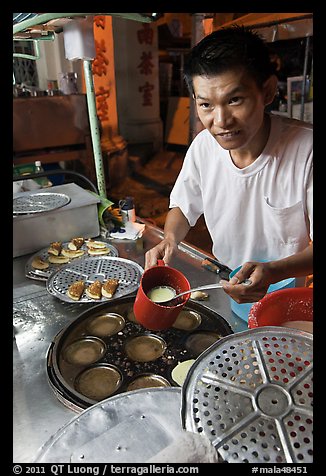 Man preparing mini-pancakes. George Town, Penang, Malaysia (color)