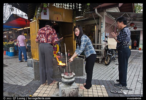 Worshiping at Buddhist street altar. George Town, Penang, Malaysia