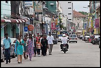 Malay people walking on street. George Town, Penang, Malaysia