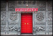 Red door and slate carved wall, Hainan Temple. George Town, Penang, Malaysia