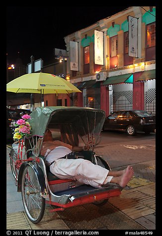 Driver taking nap in trishaw at night. George Town, Penang, Malaysia (color)
