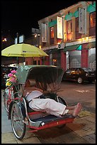 Driver taking nap in trishaw at night. George Town, Penang, Malaysia