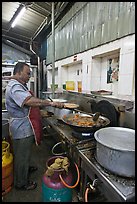 Man frying food in large pan. George Town, Penang, Malaysia (color)