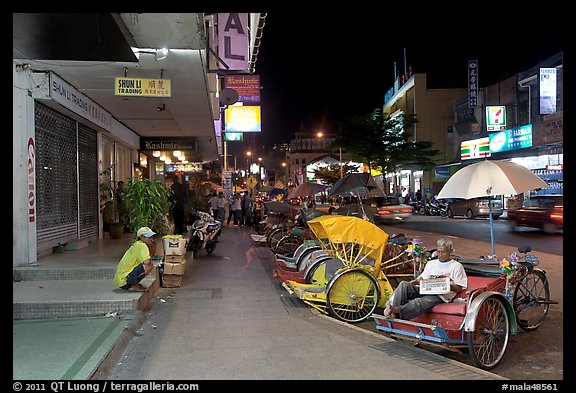 Cycle rickshaws lined on street at night. George Town, Penang, Malaysia (color)
