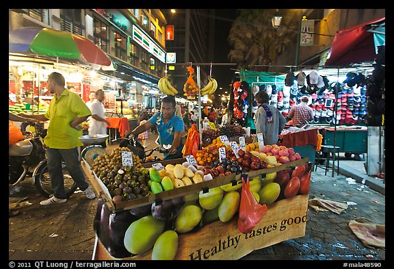 Fruit vendor pushes cart, Jalan Petaling. Kuala Lumpur, Malaysia (color)
