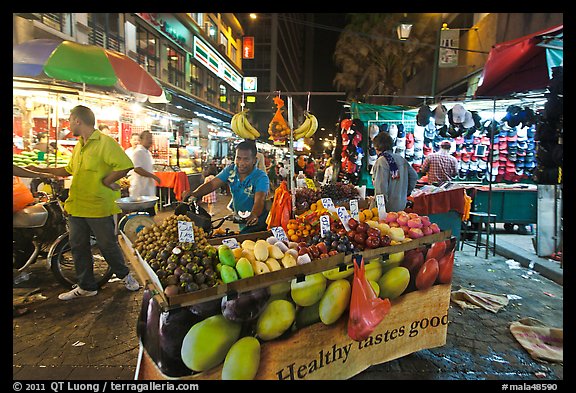 Fruit vendor pushes cart, Jalan Petaling. Kuala Lumpur, Malaysia (color)