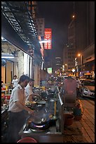 Cooks preparing food on Chinatown street at night. Kuala Lumpur, Malaysia