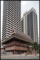 Wooden traditional building at the base of high-rises. Kuala Lumpur, Malaysia ( color)