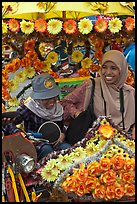 Mother and child riding decorated trishaw. Malacca City, Malaysia (color)