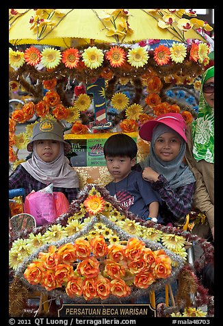 Malay children riding on trishaw. Malacca City, Malaysia (color)