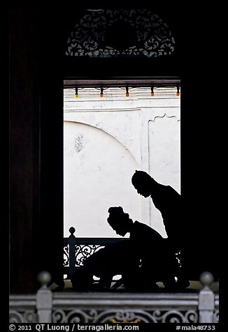 Silhouettes of men bowing in worship, Masjid Kampung Hulu. Malacca City, Malaysia