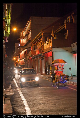 Car and bicycle rickshaw at night. Malacca City, Malaysia