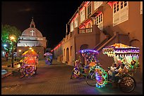 Illuminated trishaws on Town Square at night. Malacca City, Malaysia