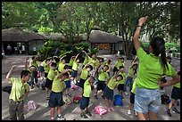 Schoolchildren doing gymnastics in  Singapore Botanical Gardens. Singapore