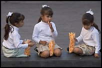 Three little girls in school uniform eating snack. Guadalajara, Jalisco, Mexico