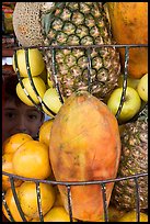 Boy peers from behind fruits offered at a juice stand, Tlaquepaque. Jalisco, Mexico