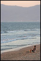 Woman sitting on the beach looking at the sunset, Nuevo Vallarta, Nayarit. Jalisco, Mexico