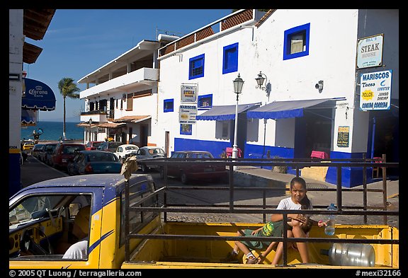 Girl riding in the back of pick-up truck in a street close to ocean, Puerto Vallarta, Jalisco. Jalisco, Mexico (color)