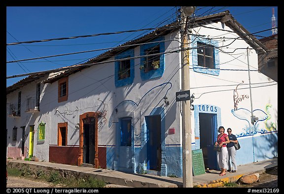 Two women outside of corner house with colorful door and window outlines, Puerto Vallarta, Jalisco. Jalisco, Mexico