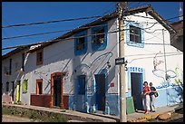 Two women outside of corner house with colorful door and window outlines, Puerto Vallarta, Jalisco. Jalisco, Mexico